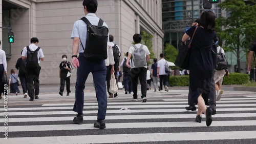 横断歩道を渡り朝の通勤するビジネスマンたちの後ろ姿のスローモーション　丸の内