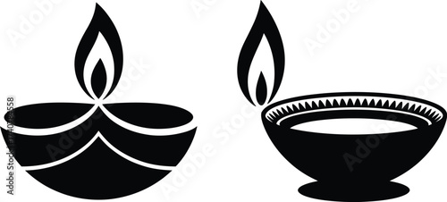 Two black silhouette diya lamps with flames representing light and celebration