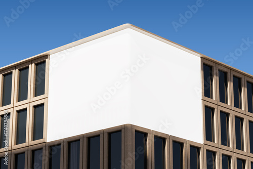 Photography Blank white billboard mockup on modern building corner facade under clear blue sky for outdoor advertising and poster design concept display