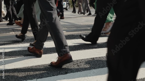 横断歩道を渡り朝の通勤するビジネスマンたちの足元のスローモーション　東京
