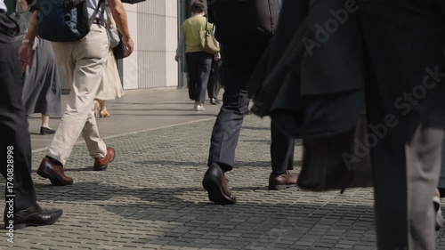 朝の通勤するビジネスマンたちの後ろ姿の足元のスローモーション　東京