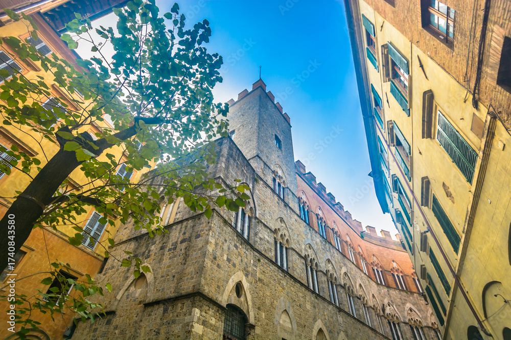 Naklejka premium Photo of Siena in Tuscany showing monumental medieval buildings, stone facades, red brick architecture, historic towers and authentic Italian atmosphere in the cultural old town