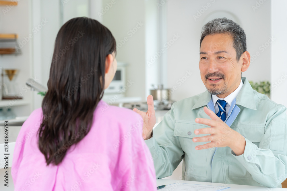 Obraz premium リビングで主婦と商談をするセールスマン