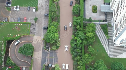 Aerial drone shot following cars moving on a heavily flooded road in between posh societies showing the lack of infrastructure in indian cities like gurgaon, noida, delhi, mumbai