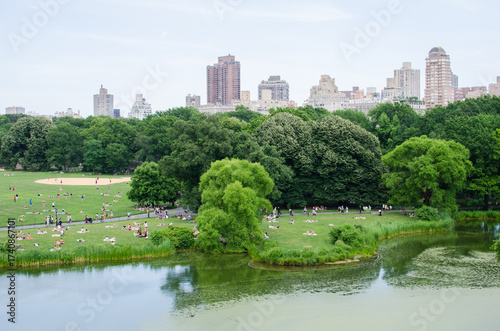 People relaxing in Central Park with city skyline