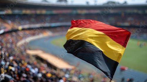 Uganda's national flag waving proudly in a packed sports stadium, showcasing vibrant colors and national pride during an event.