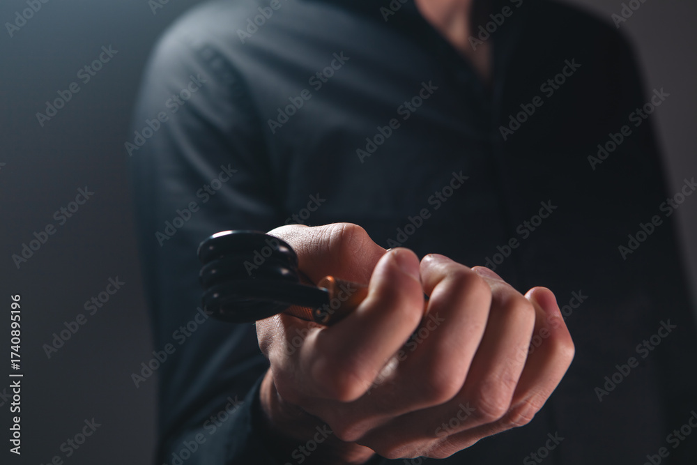 Fototapeta premium Man in a black shirt holding an electronic cigarette in his hand.