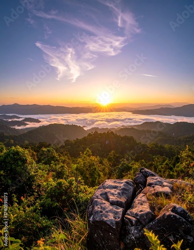 A vibrant sunrise over a landscape of hills and fog