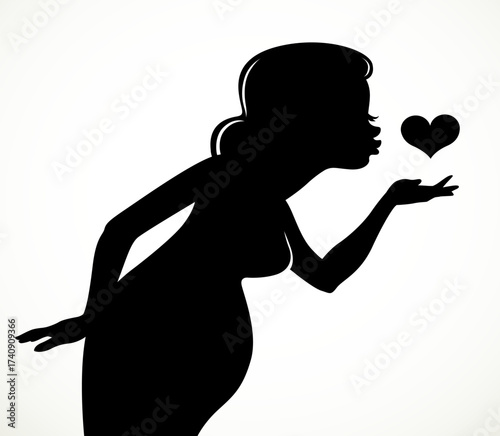 Black silhouette of a beautiful pregnant woman sending an air kiss to the heart isolated on a white background