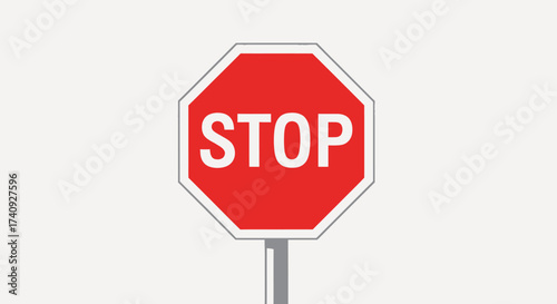A stop sign of octagonal shape with white letters on red background. It has a gray border and post