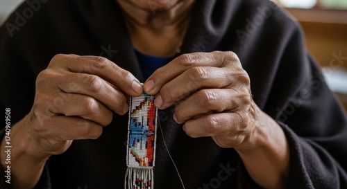 closeup of elder's hands meticulously crafting traditional beadwork. intricate process of creating colorful, geometric pattern. native american heritage, art, and culture.