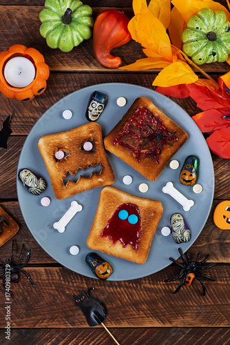 Kids Halloween sandwich with decoration and candys. Sandwiches with toast and strawberry jam