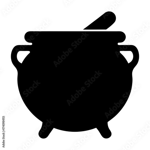 A black cauldron, witch's cooking pot, complete with stirring spoon or stick
