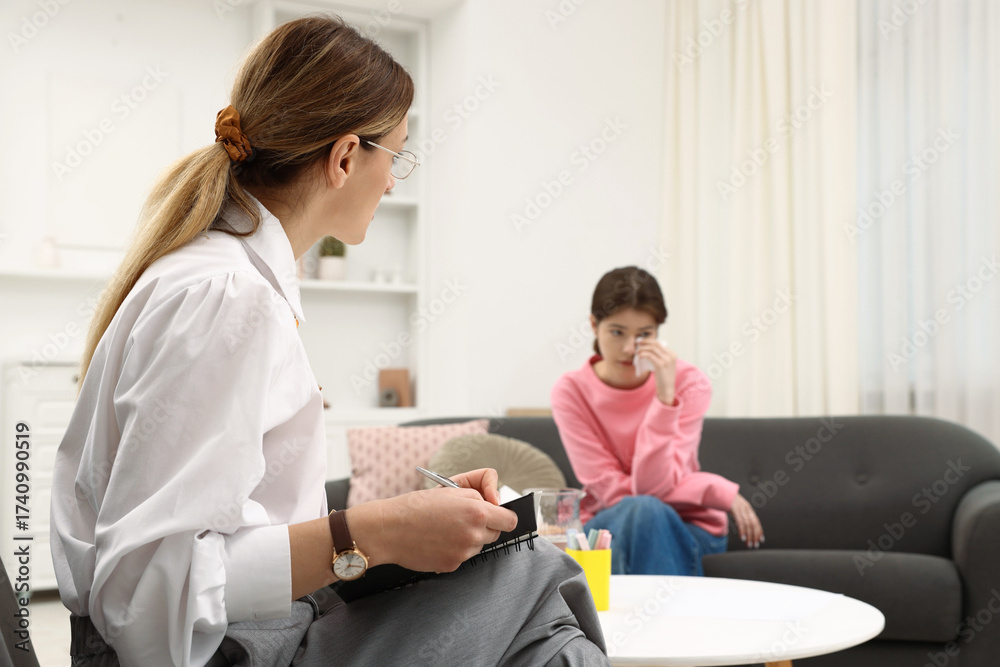 Fototapeta premium Professional psychologist working with teenage girl in office, selective focus