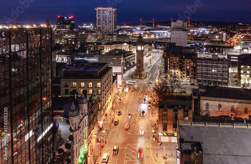 Wide-angle long exposure of High Street and Queen’s Square at night, with blurred traffic and Belfast cityscape lights.