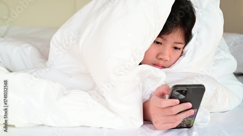 kid watching tablet on the bed, child addicted cartoon
