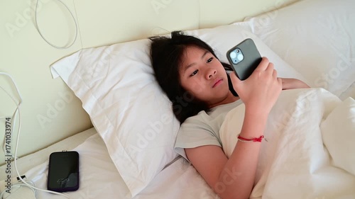 kid watching tablet on the bed, child addicted cartoon
