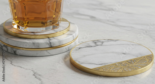 Elegant white marble coasters with gold accents on a stone surface, with a glass of whiskey resting on a stack