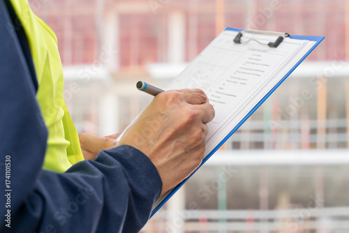 Hands, engineer and clipboard in city for checklist, inspection notes or safety compliance. Person, writing with documents for urban development, project management or supervisor paperwork and pen
