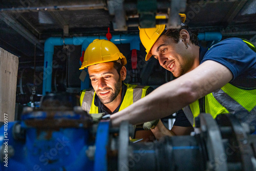 Engineers inspecting industrial pipeline system underground