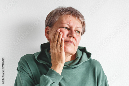 Tableau sur toile Isolated portrait of senior white woman with short gray hair in green hoodie tou