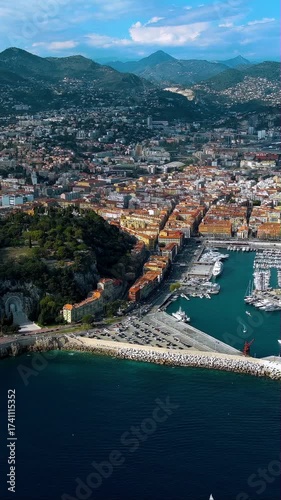 Breathtaking 4K vertical aerial video of Nice harbor with sailboats, Mediterranean Sea and Alpine mountains. Epic drone footage capturing French Riviera port and coastline panorama, perfect for mobile