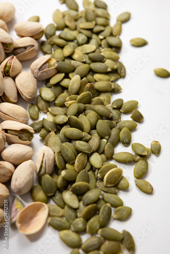 Close up of green pumpkin seeds on light surface