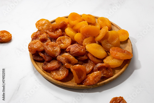 Close up of two types dried apricots on wooden plate