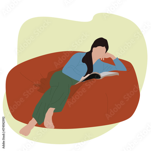 woman sitting on a bean bag reading a book