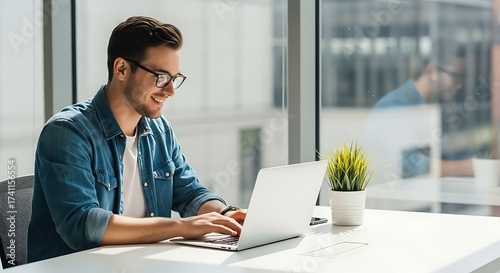 Smiling young man using laptop computer working from home office