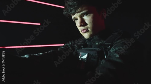 4k Dark Shot of a Young Soldier Holding the Gun Serious