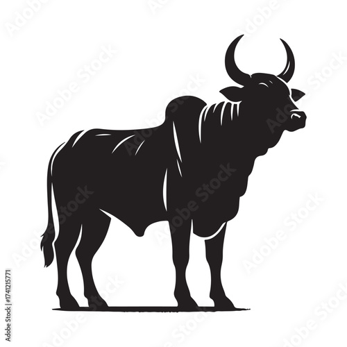 Silhouette of a majestic bull with prominent horns standing on a grassy field