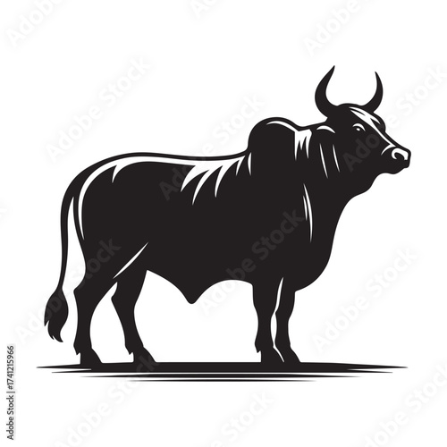 Silhouette of a majestic bull with prominent horns standing on a grassy field