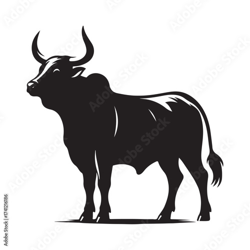 Silhouette of a majestic bull with prominent horns standing on a grassy field