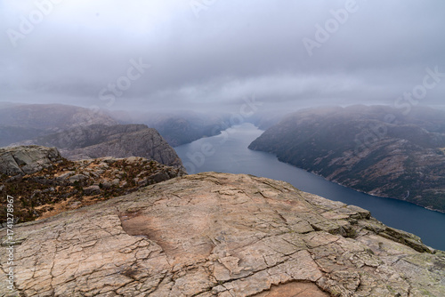 Aerial view of the Preikestolen rocky cliff, tranquil Lysefjornden fjord in Norway, rainy gloomy day and dramatic sky