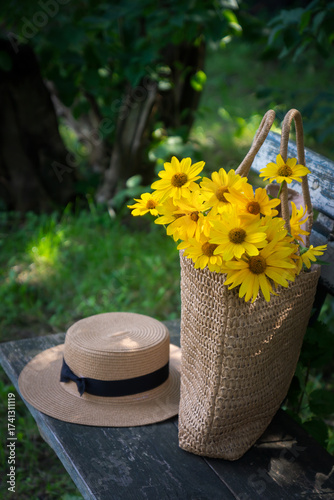 Wild flowers in a beautiful straw bag and a straw hat.
