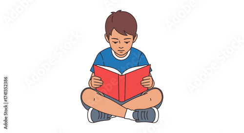 Young boy sitting cross-legged engrossed in reading a red book.