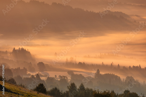 Fototapeta Naklejka Na Ścianę i Meble -  Jesienny widok na góry i spokojny krajobraz z mgłą i słońcem o świcie, Beskidy, Polska, tło lub fototapeta