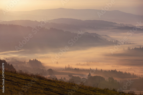 Fototapeta Naklejka Na Ścianę i Meble -  Jesienny widok na góry i spokojny krajobraz z mgłą i słońcem o świcie, Beskidy, Polska, tło lub fototapeta