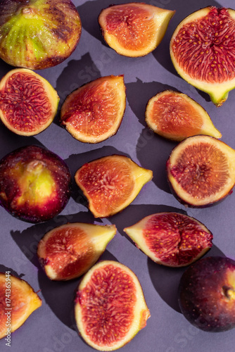 Fresh figs seamless pattern on purple color background, flat lay, top view, front view, tropical fruits texture. fresh ripe sliced figs on table.