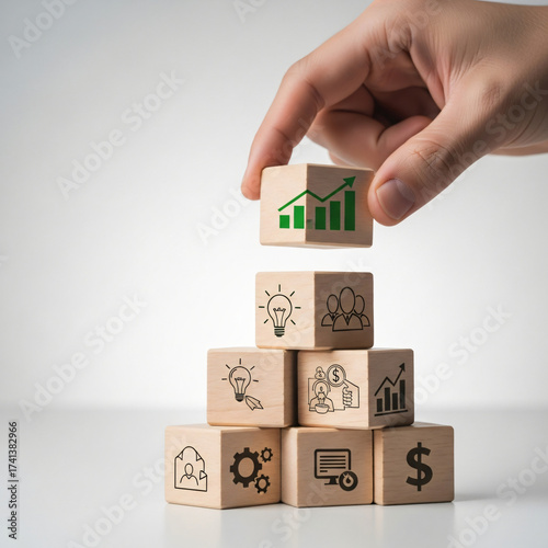 Strategically building a pyramid of wooden blocks with business icons symbolizing innovation, teamwork, and impressive financial growth and success.