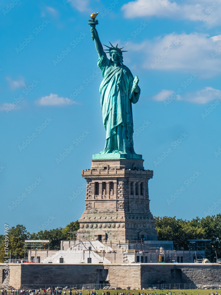 Fototapeta premium World famous Statue of Liberty under a blue sky with white clouds