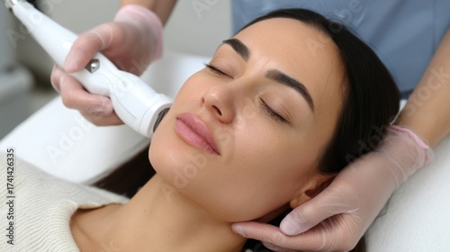 Close-up of a woman undergoing a fractional radiofrequency facelift treatment for skin rejuvenation at a medical spa.