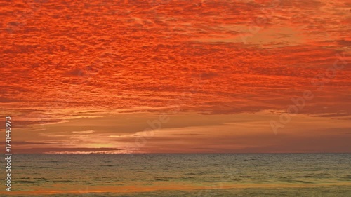 As the sun sinks below the horizon, the clouds ignite with radiant light, creating a dreamy, romantic glow over Karon Beach. A breathtaking sunset unfolds, where fiery skies meet serene waters