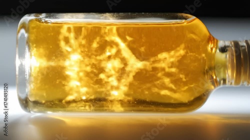 Golden Liquid Swirling Inside Glass Bottle Dynamic Motion Effect
