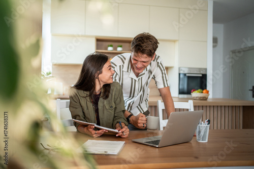 Young couple planning finances together at home kitchen
