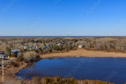 Beautiful seaside view showcasing coastal houses and a serene lake under a clear blue sky in a peaceful community