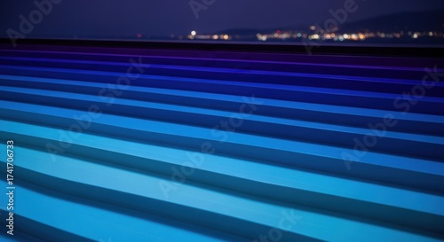 Colorful Illuminated Modern Roof Structure at Night with City Lights in Background