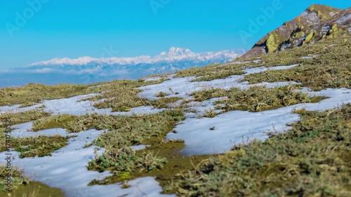 Melting Snow Time Lapse on Mountain Meadow Revealing Spring Grass