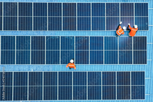 Male engineer installing solar photovoltaic panel system, Electrician or worker mounting solar module technology on power industrial factory roof, Alternative, renewable, sustainable energy. Top. view